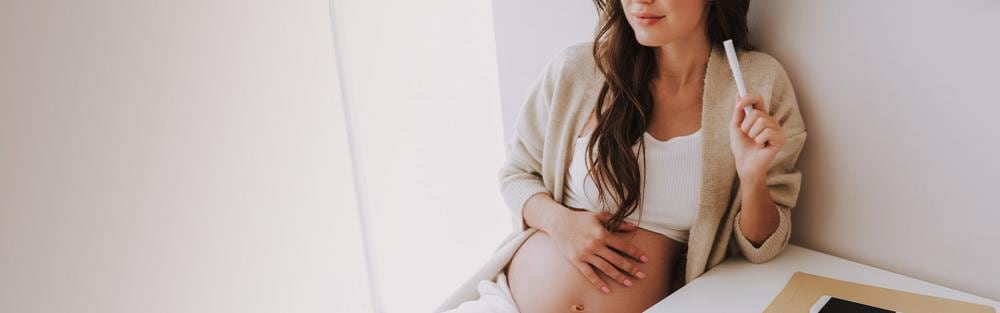 jovem segurando a mão na barriga