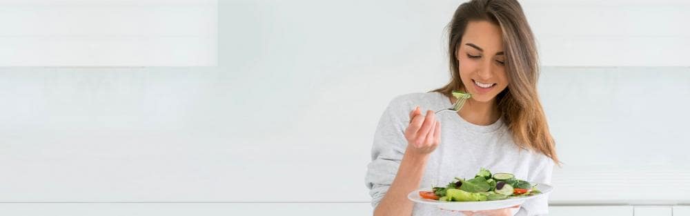 Mulher comendo uma salada
